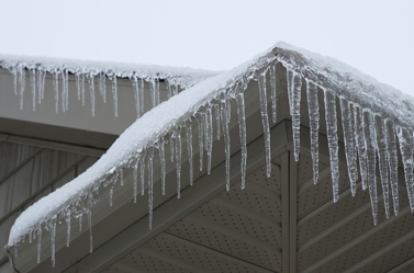 Icicles forming on the evestrough of a house after a winter ice storm. Texas homeowners and business owners who need to assess the ice and water damage that has devastated their properties.