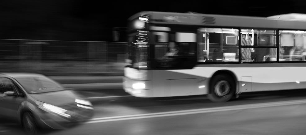 A public transport bus and a car almost colliding into each other. 